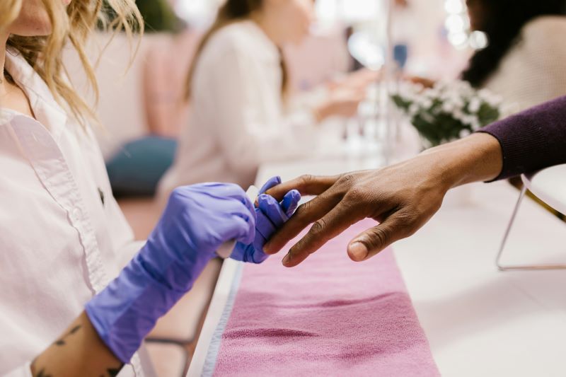 Estudiante de peluquería y estética llevando a cabo una manicura