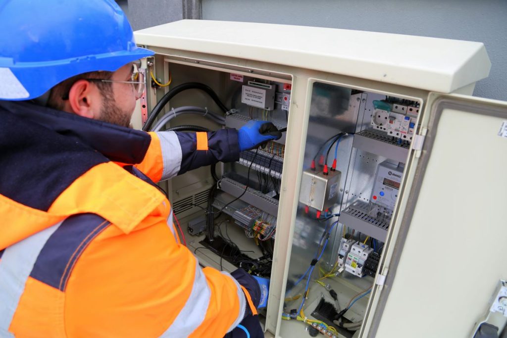 Trabajador graduado en el GB en instalaciones electrotécnicas comprobando las conexiones